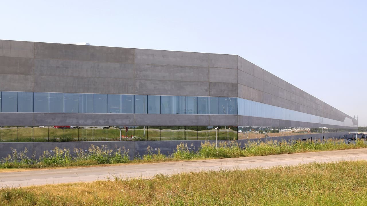 Long grey and glass facade of the Tesla Gigafactory Texas building near Austin