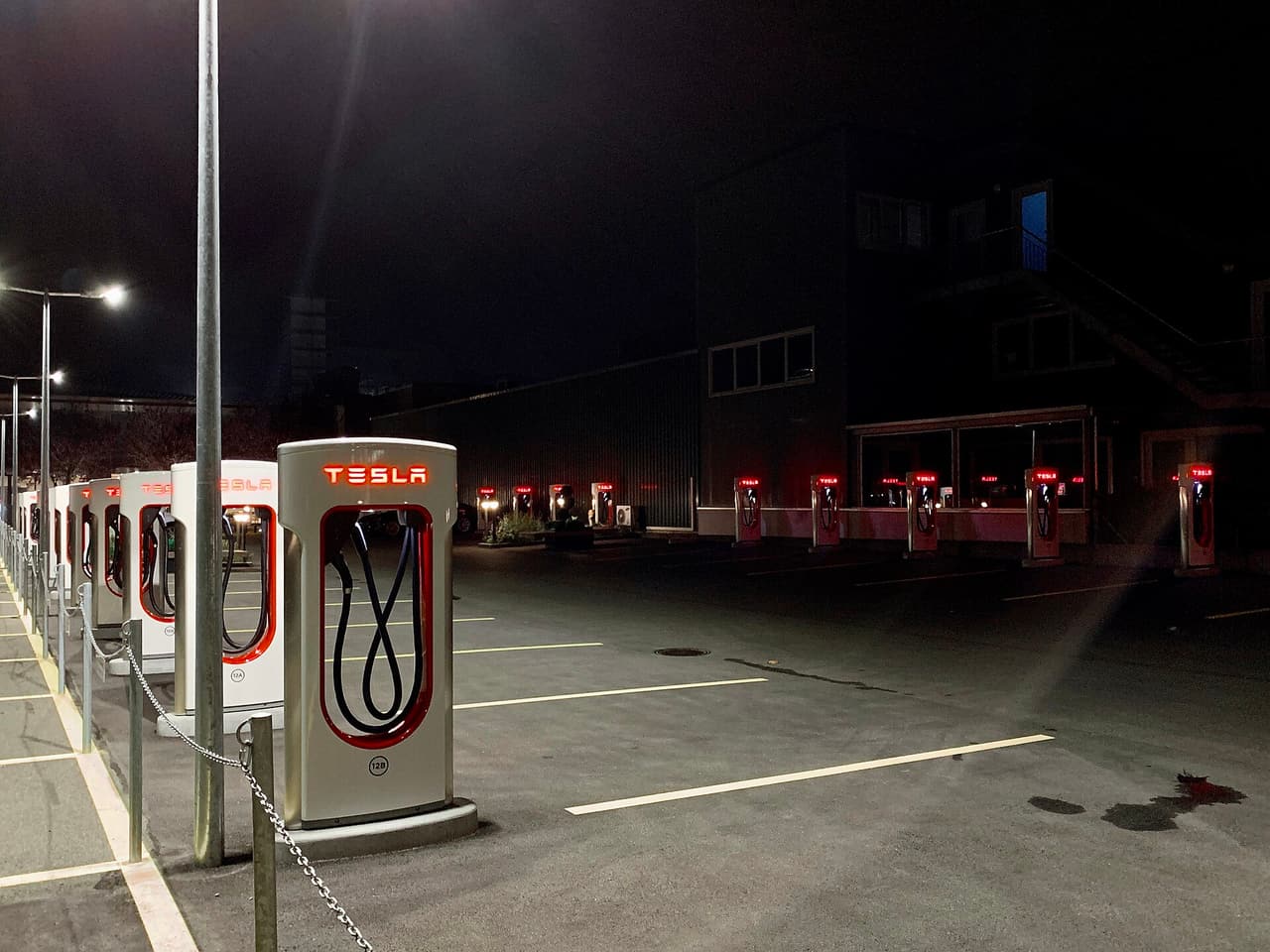 Row of Tesla Supercharger stalls lit at night